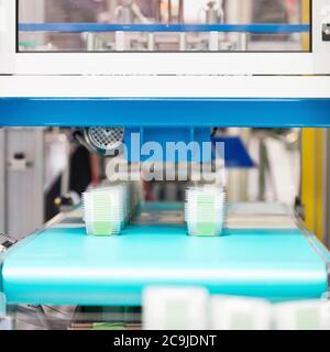 Manufacturing line, production of plastic containers for food industry. Stock Photo