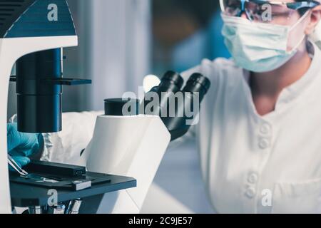 Microbiologist using light microscope. Stock Photo