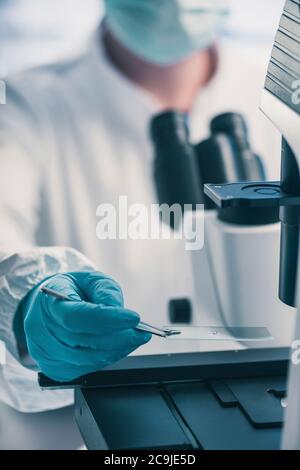 Microbiologist using light microscope. Stock Photo