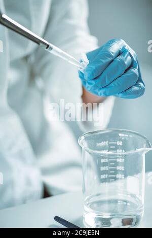 Microbiology. Hands of a microbiologist pipetting sample. Stock Photo