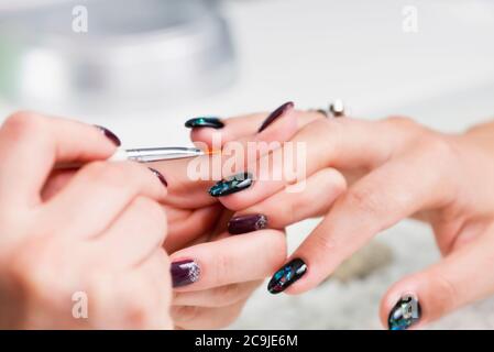 Painting fingernails in nail salon. Stock Photo