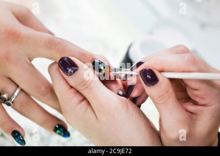 Nail technician painting nails. Stock Photo
