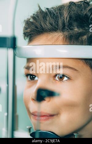 Ophthalmologist examining boy's eyes with a slit lamp . Stock Photo