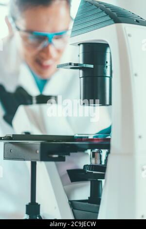Female chemist or lab technician researching samples in laboratory. Stock Photo