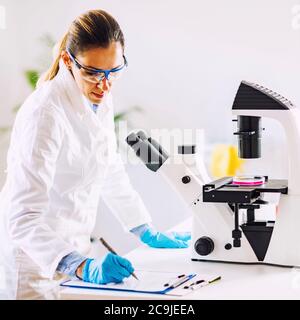 Female chemist or lab technician researching samples in laboratory. Stock Photo
