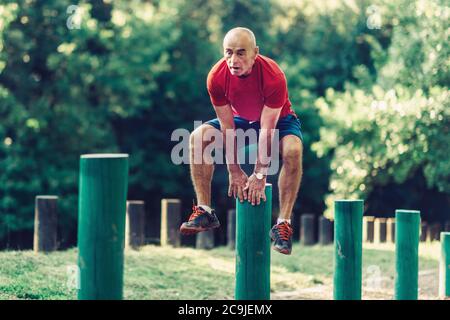 Fit senior man exercising in a park. Stock Photo