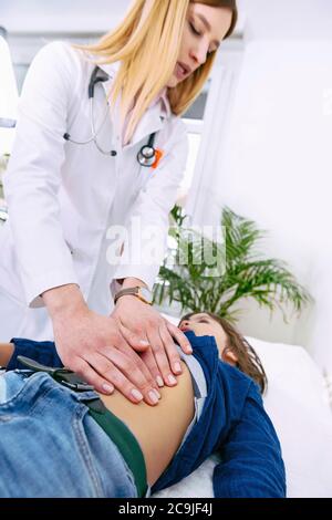 Paediatrician doing abdominal examination with hands. Stock Photo