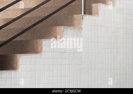 brown stone stair with white old small square tiles wall architecture background Stock Photo