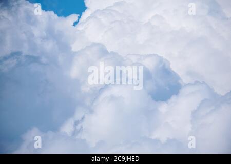 Large white clouds with thunderstorms in the blue sky. Stock Photo