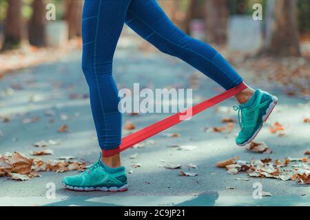 Woman exercising with resistance band in a park. Stock Photo