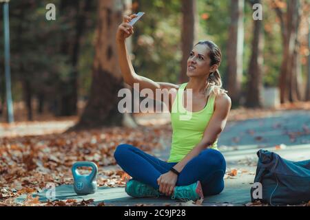 Woman taking selfie after training outdoors. Stock Photo