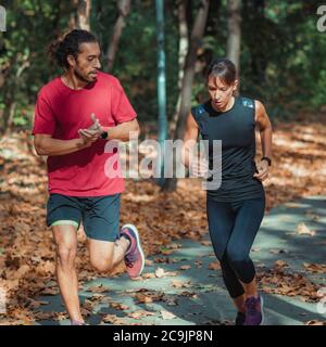 Couple jogging outdoors in park. Stock Photo