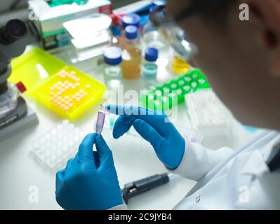 Scientist closing the lid on a vial ready for automated analysis. Stock Photo