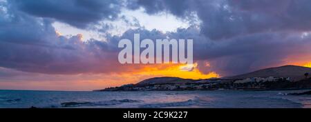 Sun setting behind mountains. Stock Photo
