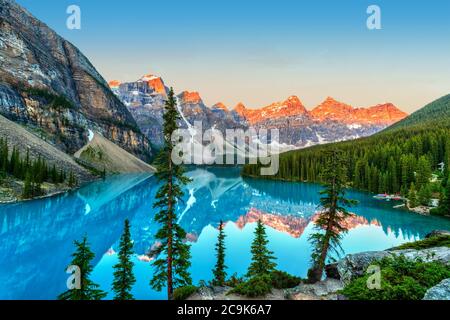 Golden sunrise over the Valley of the Ten Peaks with glacier-fed turquoise-colored Moraine Lake in the foreground near Lake Louise in the Canadian Roc Stock Photo