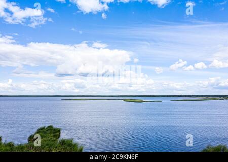 aerial view of blue lake and forest on horizon with beautiful cloudscape Stock Photo