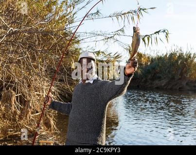 Portrait of afro fisherman holding fishing rod with fish on hook Stock Photo - Alamy Portrait of afro fisherman holding fishing rod with fish on hook Stock Photo - Alamy