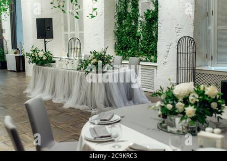 Presidium of the newlyweds at the wedding. Focus on table setting in a restaurant for a holiday Stock Photo