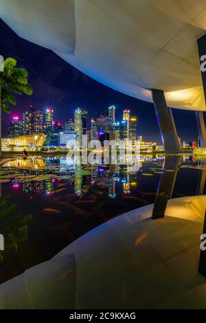 Night photography of the cityscape and waterfront along the marina bay sands hotel and art science museum in Singapore Stock Photo