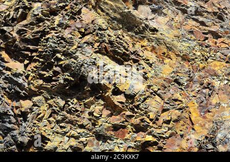 Texture of a relief rock made of yellow and brown stone. Geology. Stock Photo