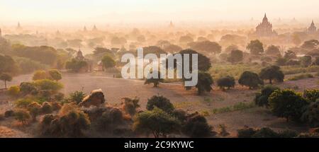 Silhouettes of ancient Buddhist temples in Bagan, Myanmar during sunset. Aerial view. Panoramic landscape Stock Photo