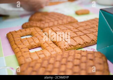 making a gingerbread house on kitchen table Stock Photo