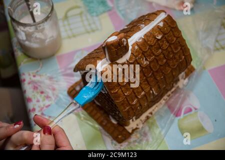 making a gingerbread house on kitchen table Stock Photo