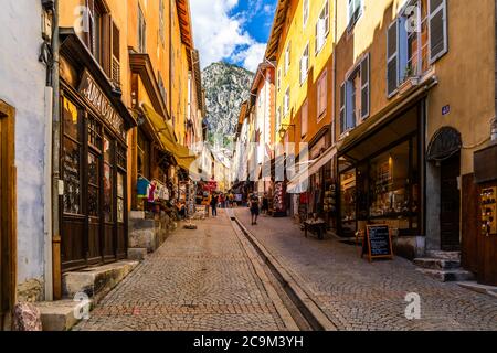briancon-old-town-main-street-with-colorful-houses-and-tourists-walking