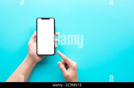 Female hand using smartphone with blank screen on color background.technology and connectivity concepts Stock Photo