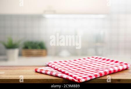 Red fabric,cloth on wood table top on blur kitchen counter (room)background.For montage product display or design key visual layout. Stock Photo