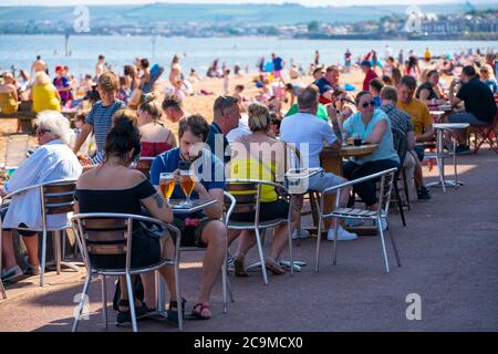 Edinburgh, Scotland, UK. 31 July, 2020. Temperature of 25C and sunshine brought huge crowds to Portobello Beach outside Edinburgh. Several large groups of teenagers were enjoying beach and alcoholic drinks were very popular. Credit: Iain Masterton/Alamy Live News Stock Photo