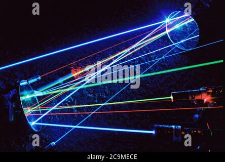 Assorted laser beams from various pointers reflecting in mirrors and intersecting. Blue, green, red and violet laser pointers. Art, science, physics. Stock Photo