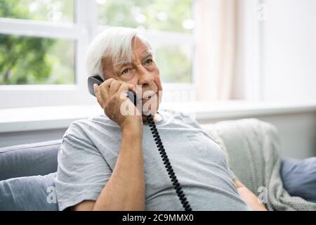 Senior Old Man Talking On Landline Telephone Stock Photo