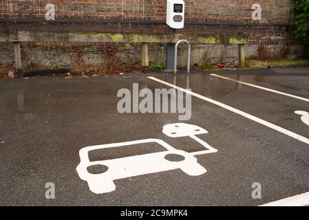 Empty car park spaces with markings for charging electric cars at Southampton central railway station UK. Stock Photo