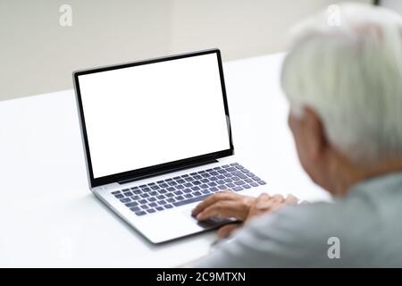Close-up Of Senior Man Using Laptop Showing Blank Screen At Home Stock Photo