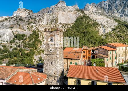 Aerial View of the bell tower of Sant Bartolomeo church in ancient village Colonnata and Apuan Alps with marble quarries, Tuscany, Italy Stock Photo