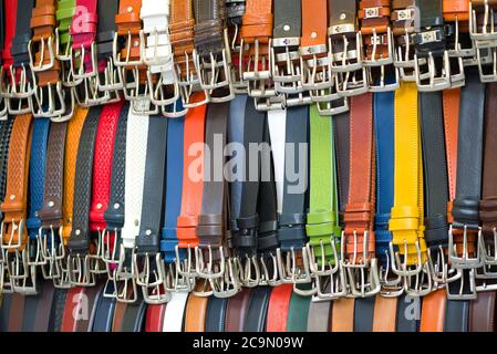 FLORENCE, ITALY - SEPTEMBER 19, 2017: Background from hanging colored leather belts. City street market of Florence Stock Photo
