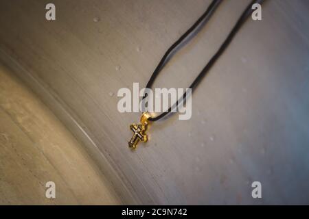 Christening accessories in the church, small golden cross at children baptismal font Stock Photo