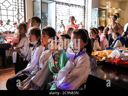 Yangxian, China's Shaanxi Province. 31st July, 2020. Children watch a traditional opera play performed by schoolmates at a primary school in Yangxian county of Hanzhong, northwest China's Shaanxi Province, July 31, 2020. To help students better learn about traditional culture and feel its charm, training sessions and exhibitions on intangible cultural heritages made by folk artisans and art education experts have been introduced into schools here during holidays and vacations for consecutive years. Credit: Lan Hongguang/Xinhua/Alamy Live News Stock Photo