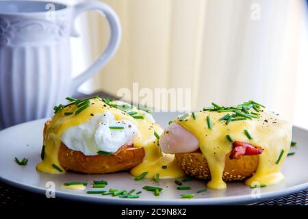 Eggs Benedict- toasted muffins, ham, poached eggs, delicious buttery hollandaise sauce Stock Photo
