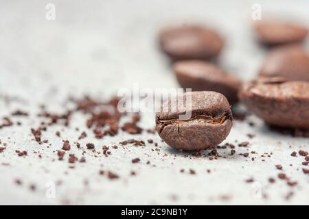 Closeup of coffee beans against a background of ground coffee. Selective focus Stock Photo