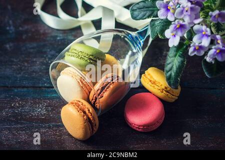 Colorful French macaroons on a dark rustic wooden background, selective focus Stock Photo
