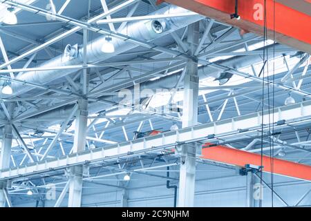 Blue Lights and ventilation system in long line on ceiling of the  industrial building. Exhibition Hall. Ceiling factory construction Stock Photo