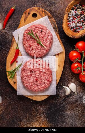 Fresh raw minced homemade grill beef burgers on wooden chopping board, top view Stock Photo