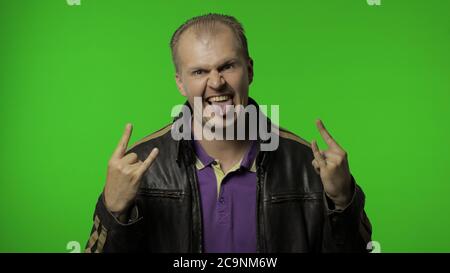 Happy rocker man in brown leather jacket showing rock and roll sign ...