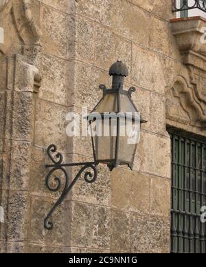 On a stone brick wall in old Havana is mounted this antique iron lantern Stock Photo