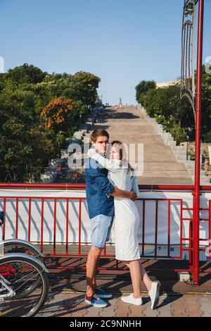 ODESSA, UKRAINE - AUGUST 06, 2015: cute young beautiful hipster couple hugging with Potemkin Stairs at background, happy smiling outdoor portrait Stock Photo