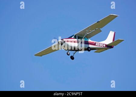 A small, single wing, single engine Cessna aircraft in a landing pattern over a small airport in Oregon. Stock Photo