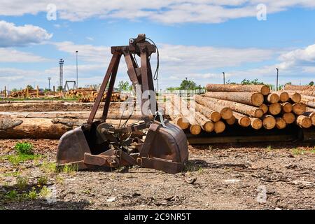old rusty grapple bucket of the excavator in the yard of a woodworking factory Stock Photo