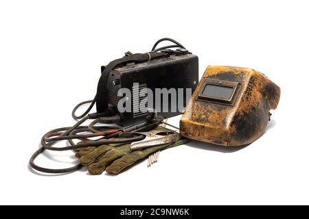 Welding mask with welding machine, protective gloves, and arc steel electrodes. Kit of used welding equipment on white background. Stock Photo